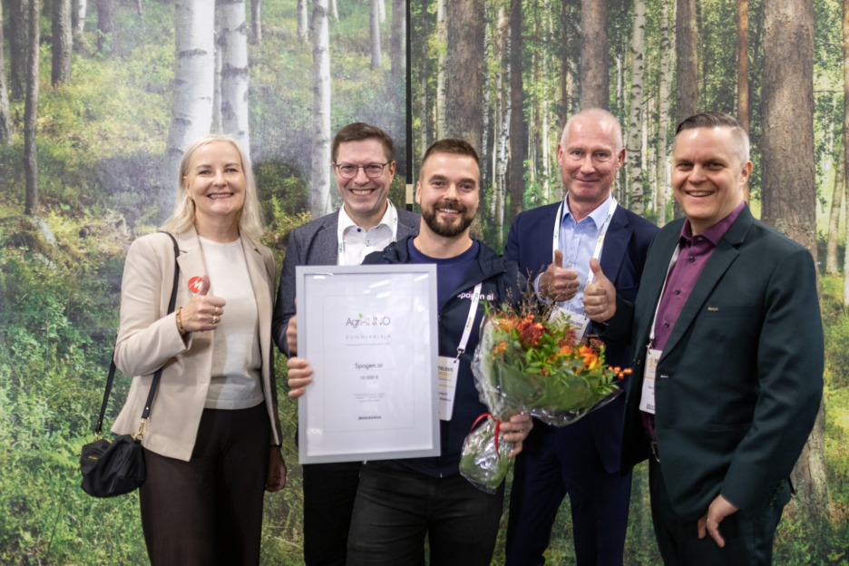 Agri-inno voittaja kunniakirja ja kukat kädessään.